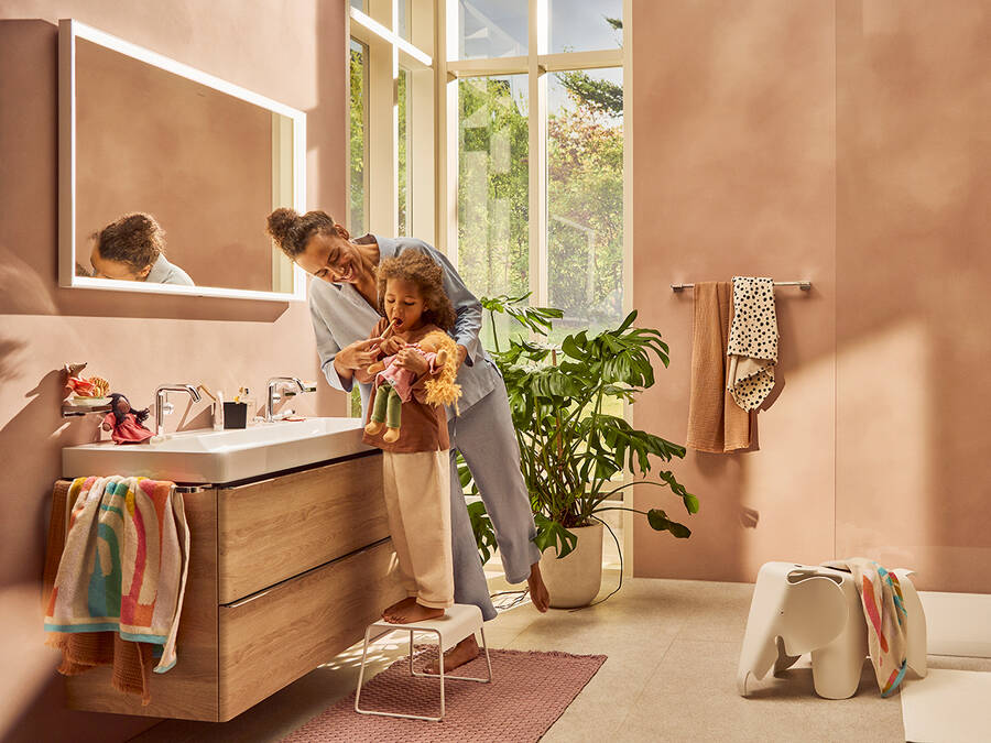 Mom helping her daughter to clean her teeth at the washplace.