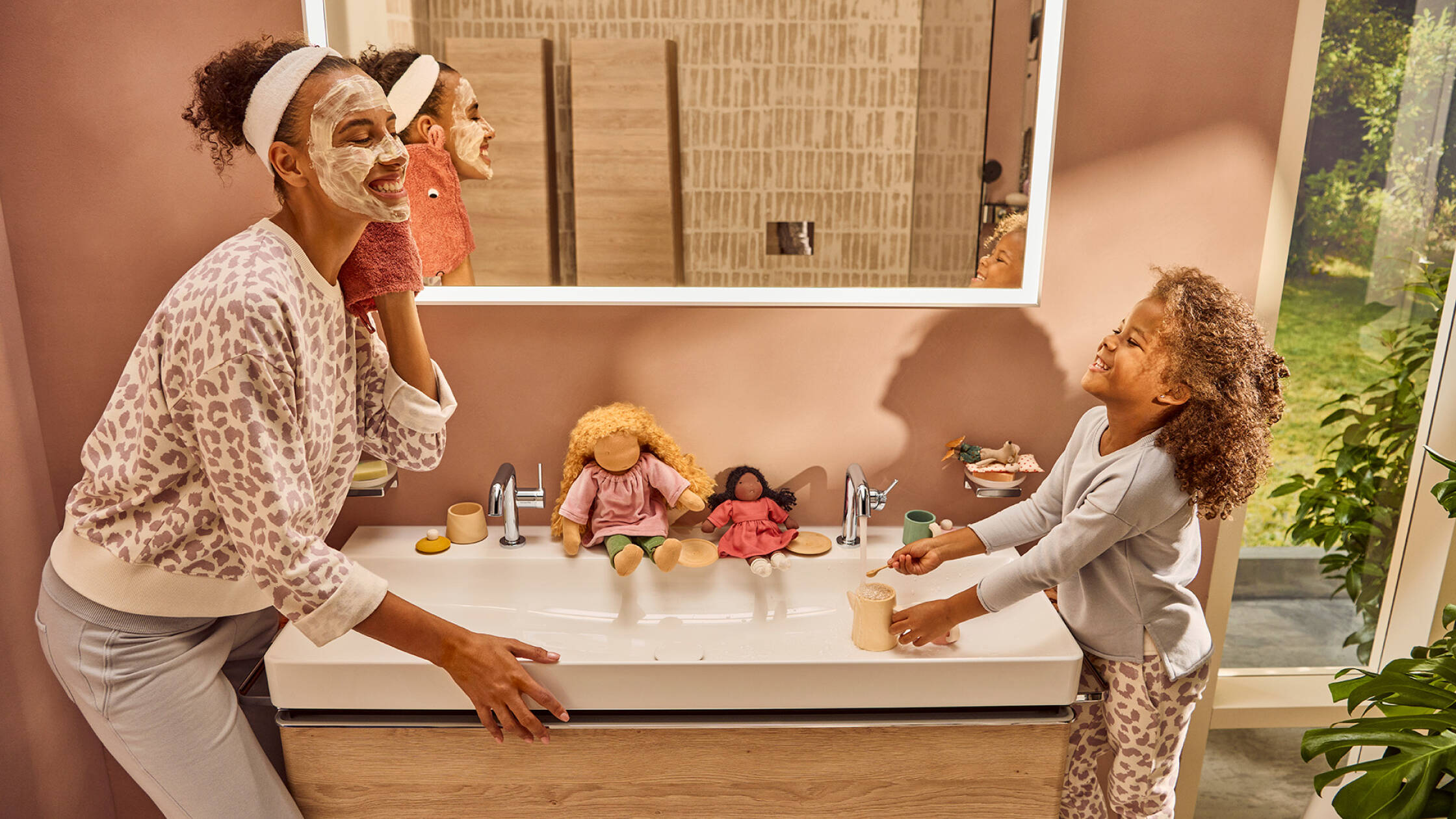 A mother and her daughter play at the hansgrohe wash basin.