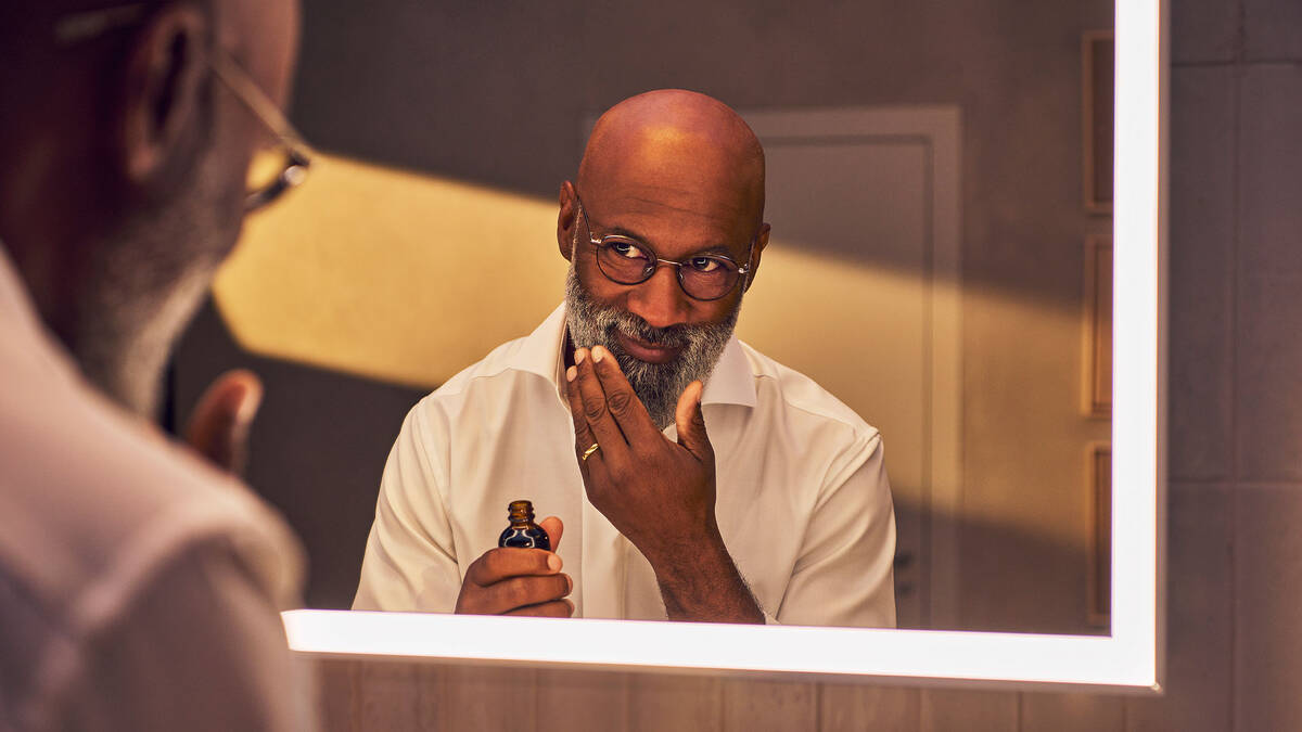 Man by the linear Xarita mirror with LED lighting.