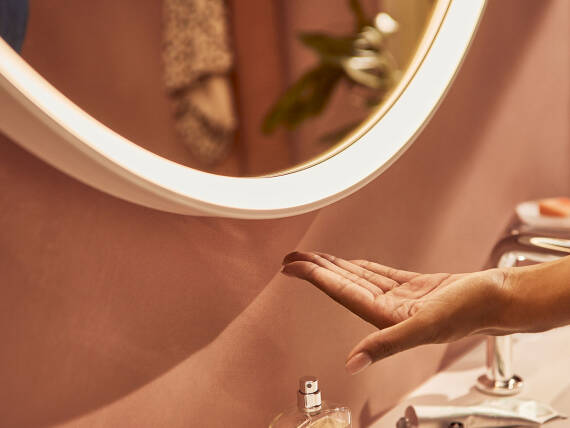 Hand moving toward the bottom of the mirror frame.