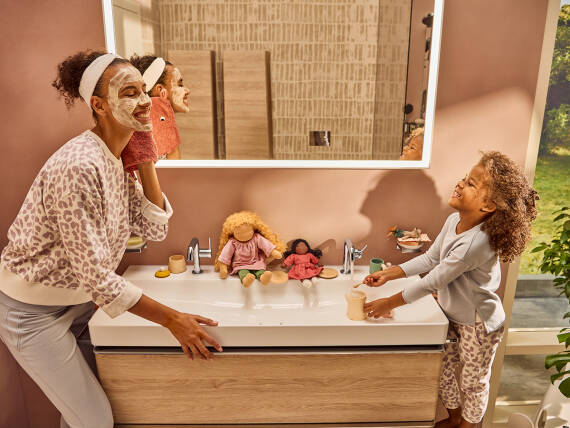 Mutter und Tochter genießen gemeinsame Momente im Wellness-Badezimmer.