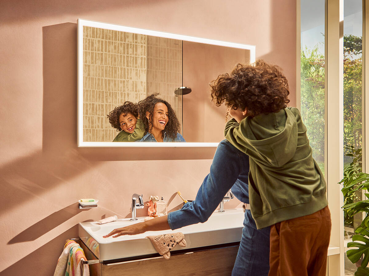 Mum and child standing in front of a linear Xarita mirror.
