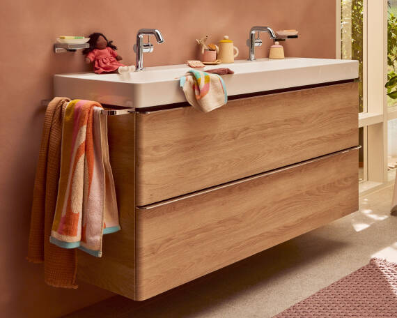 Waschtischunterschrank in Holzoptik vor Wand in Altrosa.