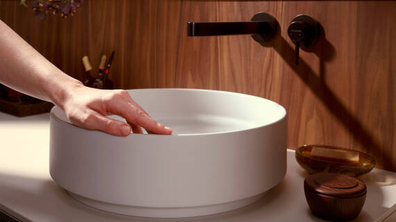 Woman's hand gliding over an exquisite hansgrohe wash basin.