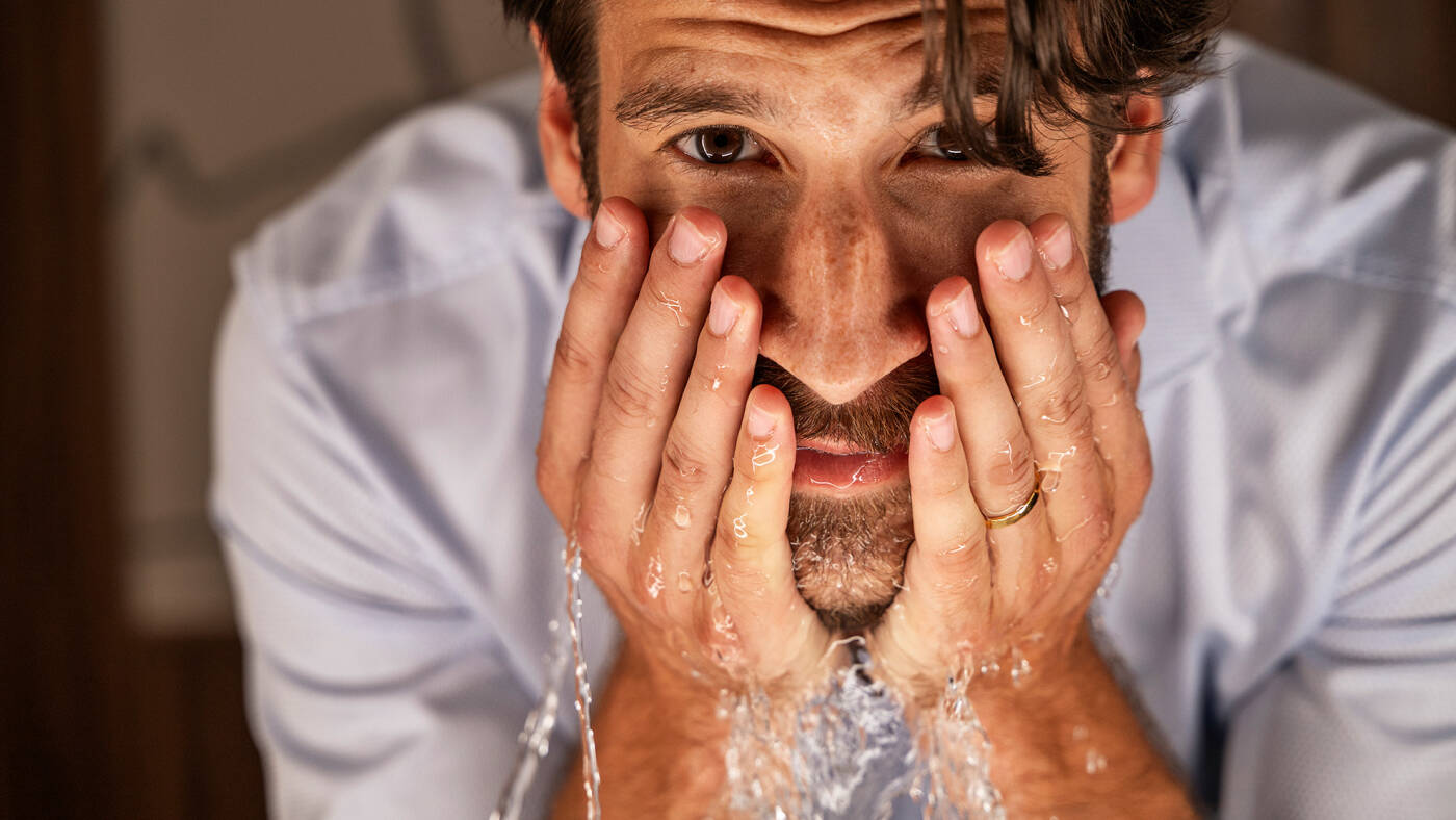 Man wast zijn gezicht in de Xuniva Evo waskom.