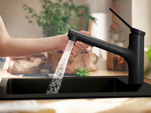 Woman fills pot at hansgrohe faucet.