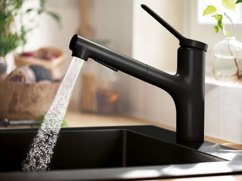 Matt sort kran med dusjstråle på kjøkkenet.