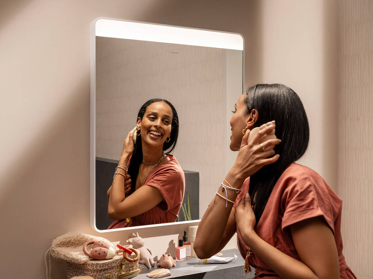 Vrouw kijkt naar zichzelf in Xarita Lite spiegel.
